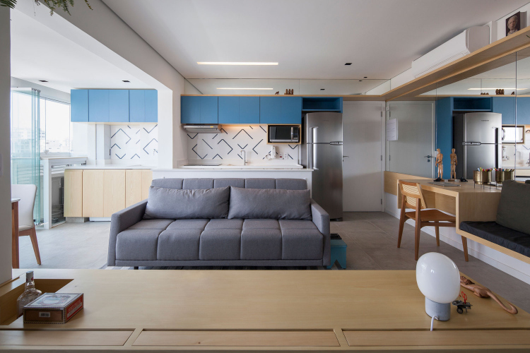 Mali stan sa kuhinjskim ormarićima u plavoj boji i nameštajem po meri